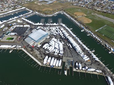 Drone view looking down on a marina's docks and rows of boats.