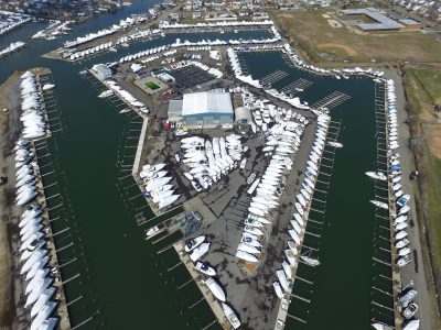 Aerial view of a marina basin filled with moored powerboats and sailboats.