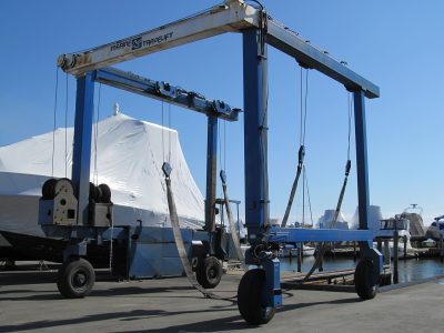 Blue marine travel lift gantry used to haul boats from the water at a boatyard.
