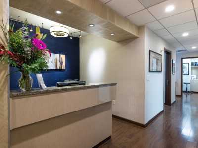 Reception and waiting area with a front desk and blue accent wall at a physical therapy clinic.
