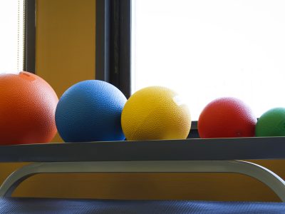 Colorful stability and exercise balls arranged in a physical therapy studio.