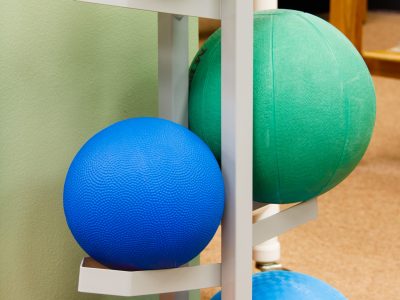 Rack of large colorful stability exercise balls at a physical therapy and rehabilitation clinic.