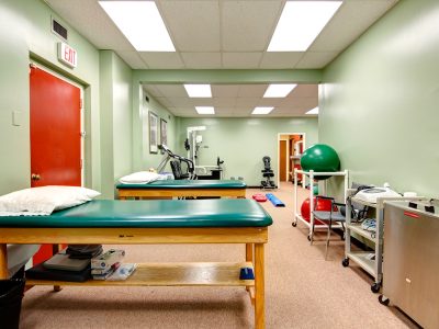 Treatment room with a therapy table and exercise ball in a physical therapy clinic.