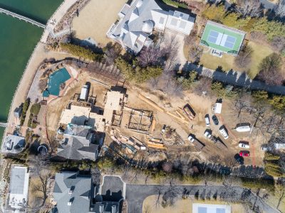 Aerial view of a luxury waterfront estate under construction in Northport, Long Island, showing the foundation, pool, and tennis court.