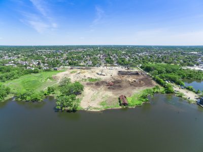 Aerial over Camden, New Jersey showing a cleared riverfront development site against the surrounding neighborhood.