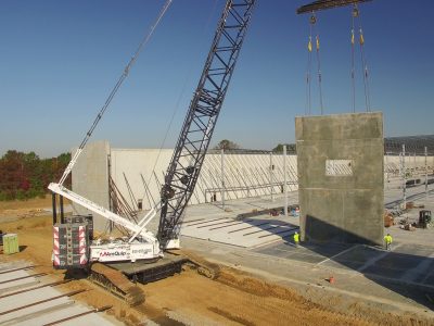 Crawler crane working alongside a large concrete and steel structure on a major New Jersey commercial building project.