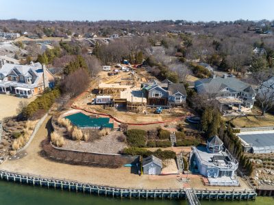 Aerial of a waterfront luxury home rebuild and the surrounding shoreline neighborhood in Northport, Long Island.