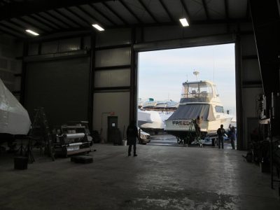 Boat parked inside a marine service building for maintenance and repair.